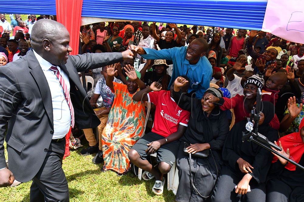 The Jinja South East Constituency MP Paul Mwiru (L) enjoying a light moment with his supporters while at his thanksgiving ceremony at Walukuba West playground on May 16th. (Credit: Donald Kiirya)