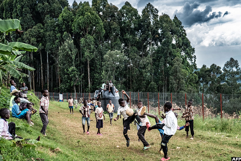 Young refugees from eastern DR Congo play football on an open field at Nyarushishi Transit Camp.