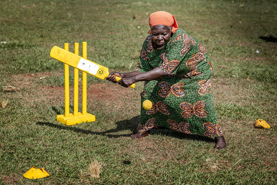An elderly woman plays a shot during a cricket and physical training session in Jinja. AFP PHOTO