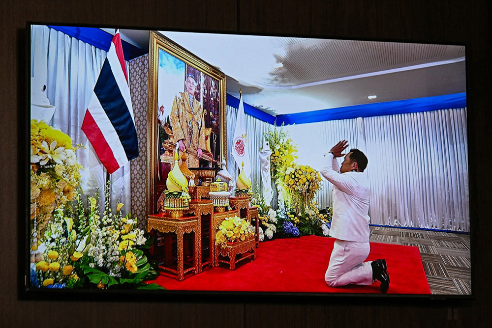 A screen displayed at the Bhumjaithai Party's headquarters shows party leader Anutin Charnvirakul paying respects to an image of Thai king Maha Vajiralongkorn during the royal endorsement ceremony appointing him as Thailand's new prime minister in Bangkok on September 7, 2025. (Photo by Lillian SUWANRUMPHA / AFP)