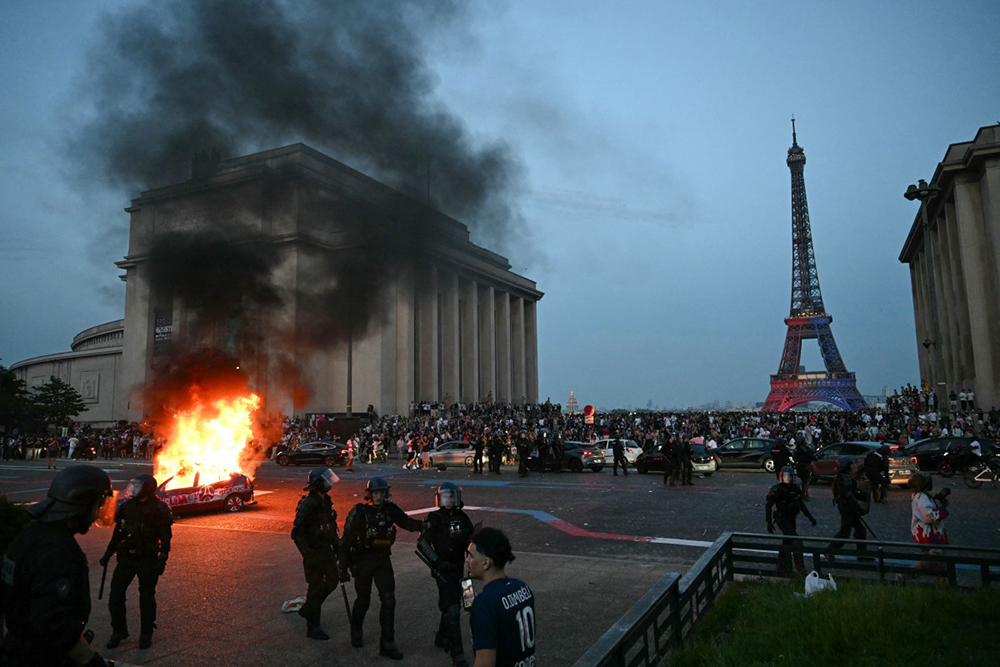 A car is set ablaze as PSG supporters celebrate their team's win in the UEFA Champions League final between Paris Saint-Germain (PSG) and Arsenal FC played in Budapest, at Place du Trocadero opposite the Eiffel Tower in Paris on May 30, 2026.