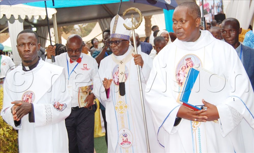Archbishopl Paul Ssemogerere (holding a crosier), Fr. Richard Kakoma (right) and the Deacon on duty (left)  during the procession. 