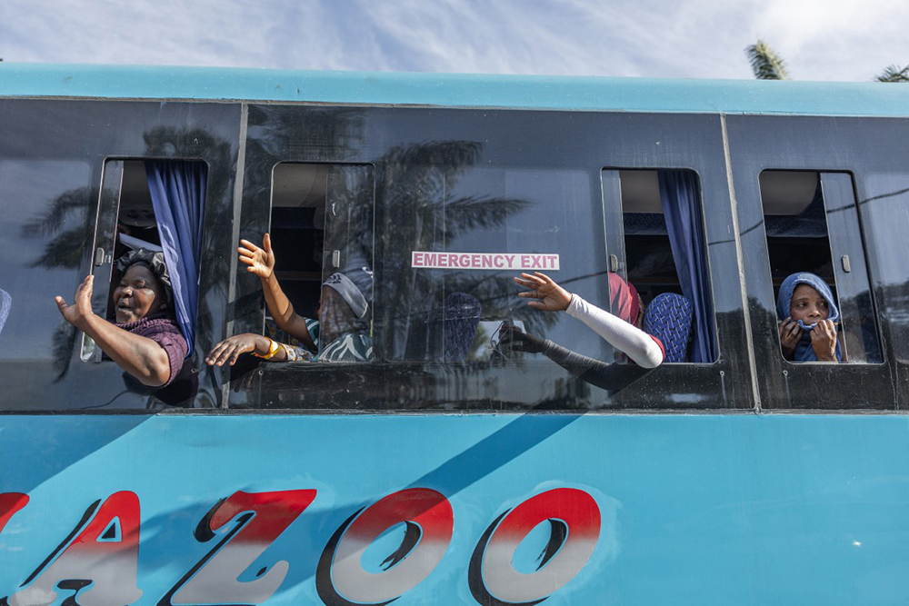 Migrants wave to people their goodbyes as the first of seven buses leave the Sherwood Park in Durban on June 14, 2026 to travel back to Malawi.