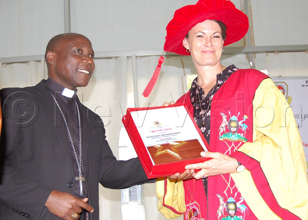 The Chairman of UMU Governing Council, Bishop Joseph Eciru Oliach gifts the Royal Danish Ambassador, Her Excellency Signe Winding Albjerg. This was during the university's graduation commencement lecture at the university's main campus in Mpigi district on Friday, October 17, 2025. (Photo by Mathias Mazinga)