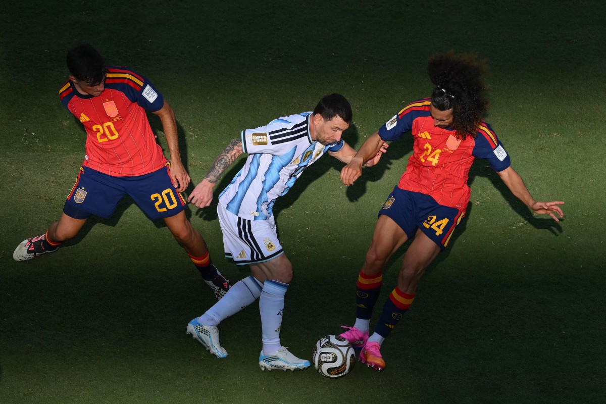 Argentina's Lionel Messi (C) fights for the ball with Spain's Pedri and Marc Cucurella. (Photo by ANGELA WEISS / AFP)