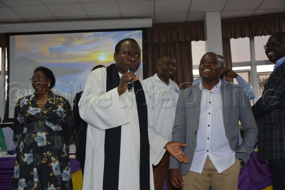 Rev. Muwonge ne Maneja wa Kampala Water Lutaaya nga bakung'aanya ssente za Mission House.