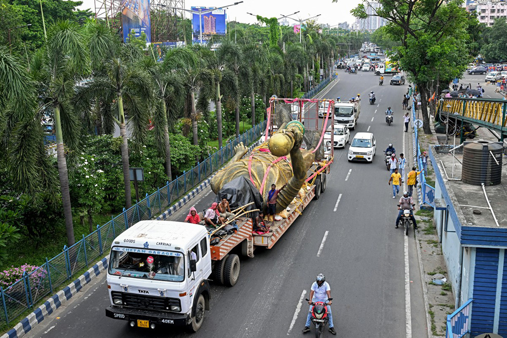 Workers transport a statue of Argentine football player Lionel Messi after its removal for re-installation to a safer place in Kolkata on June 1, 2026. (Photo by Dibyangshu SARKAR / AFP)