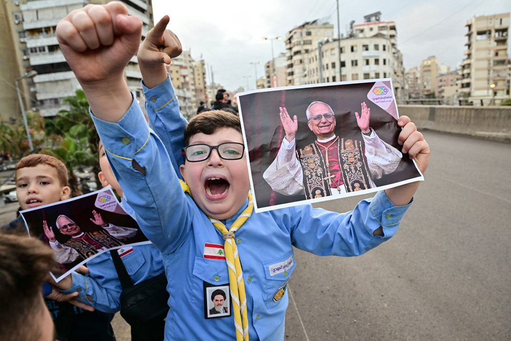 Imam Al-Mahdi scouts hold portraits of Pope Leo XIV as they wait for his arrival in Beirut's southern suburbs, a packed residential area known as Dahiyeh, which is also a Hezbollah bastion, on November 30, 2025.
