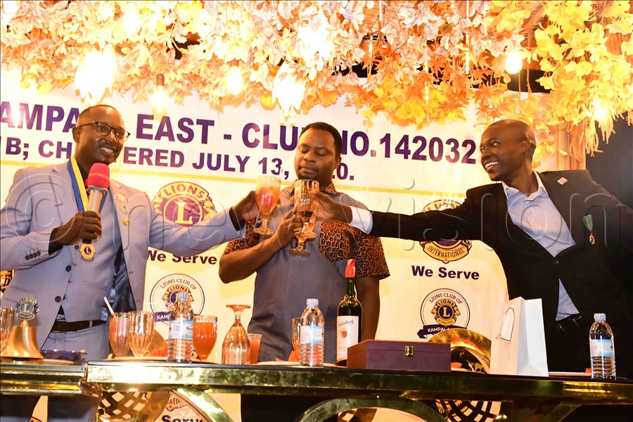 Toasting to good health. Ivan Sendege, the new president of the Lions Club of Kampala East reaches out to a guest for a toast.