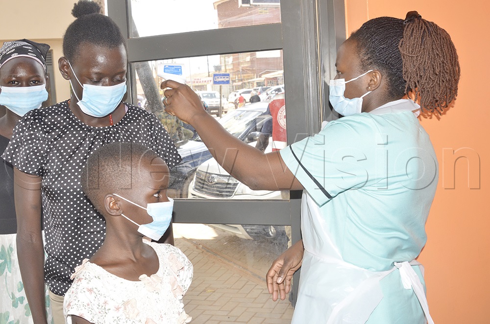 A nurse measuring a Christian before enter the Catholic Shrine premises on June 3, 2026. (Photo by Juliet Anna Lukwago)