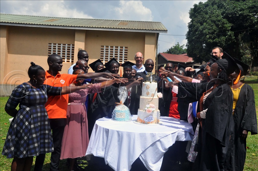 Graduates, trainers and Rotary club officials cut cake during the graduation ceremony held at BISS Bakeries Uganda in Katalemwa, Wakiso District. (Credit: John Odyek)