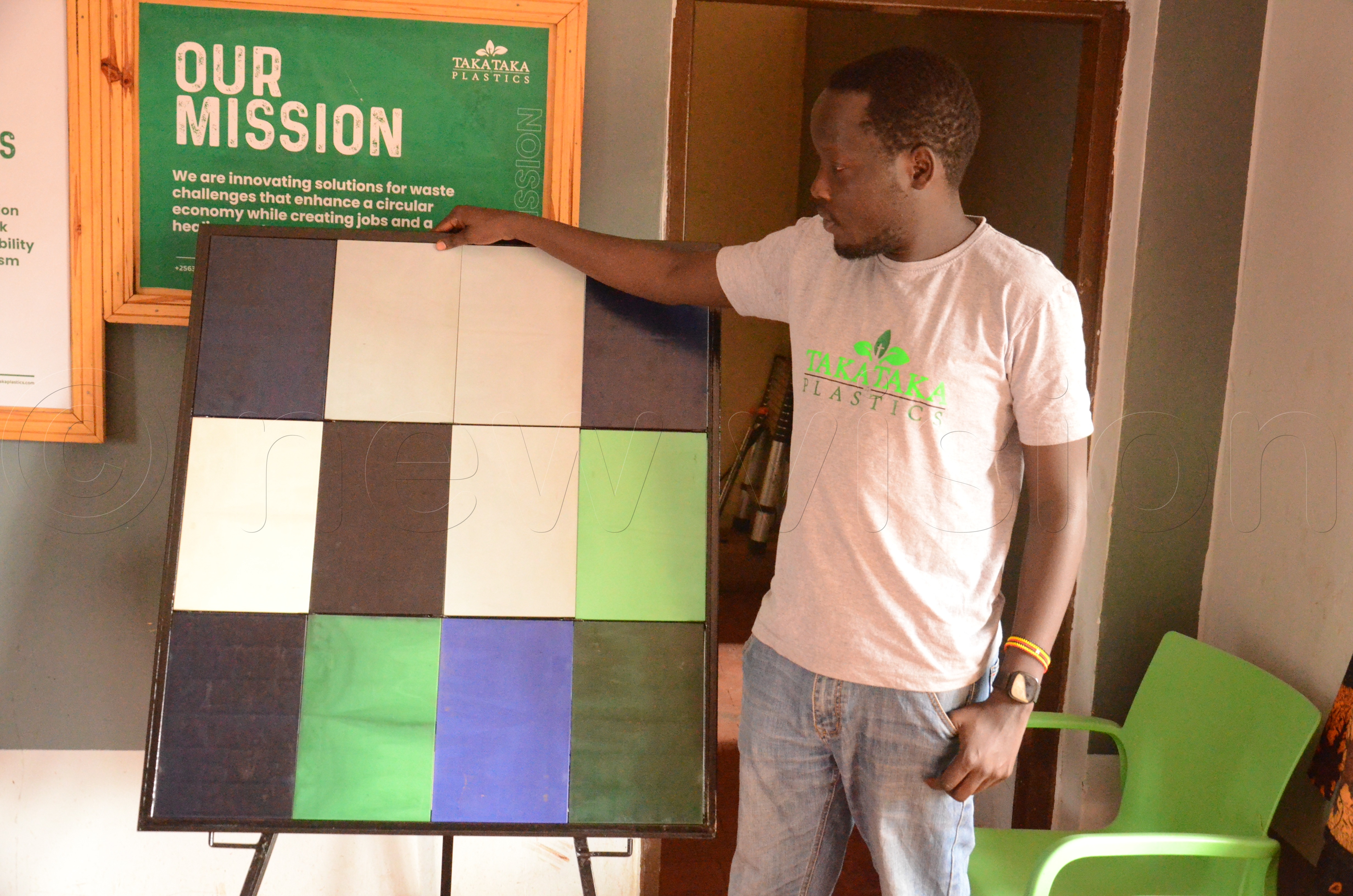 Peter Okwoko, a co-founder and chief operating officer Takataka plastics showing some of wall tilesmade from plastic bottle that they put on display.