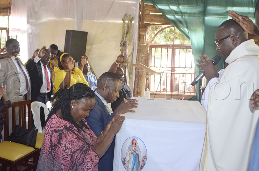 Fr Emmanuel Odongo offers prayers for Busiro South MP Kenan Opio after Mass at St Donozio Sub-Parish, Nganjo, during the parish's celebration held on June 22, 2026. (Photo by Juliet Anna Lukwago)