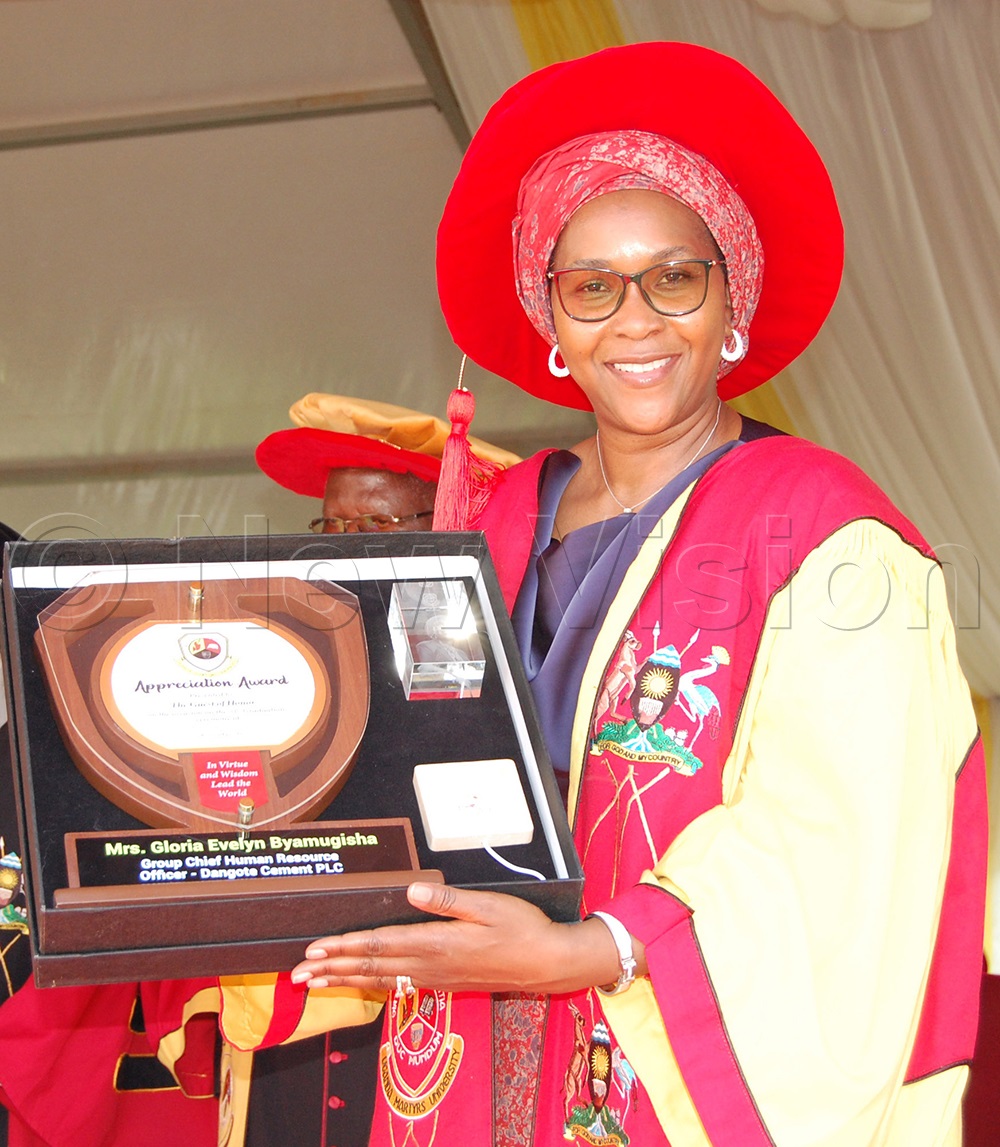 The Guest of Honor, Lady Gloria Byamugisha exposes the accolade that she receievd from UMU's Governing Council. This was during the university's 31st Graduation Ceremony at the main campus in Mpigi district on Saturday, October 18, 2025. (Photo by Mathias Mazinga)