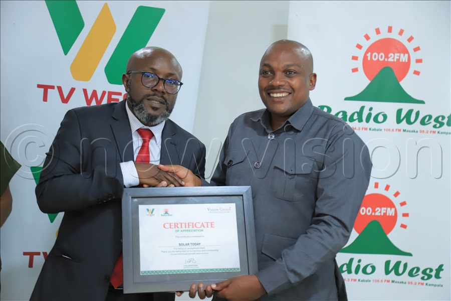 Wanyama hands over a certificate of appreciation to Kenneth Muhwezi from Solar Today during the Vision Group South Western advertisers’ engagement held on Friday.