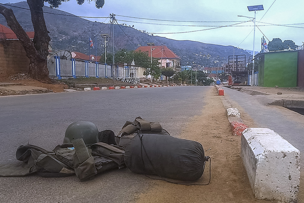 A bullet proof vest carrying a patch with the Democratic Republic of Congo (DRC) flag and a ballistic helmet are left abandoned with other personal belongings in a street in Uvira on December 11, 2025. (Photo by AFP)