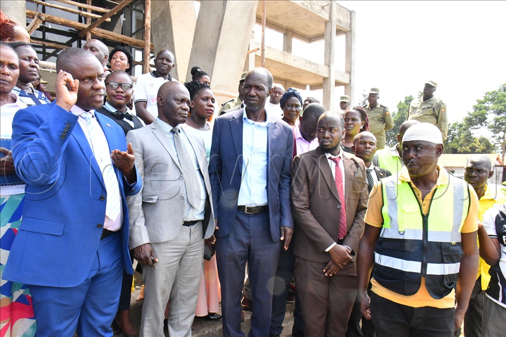 Local Government Minister Balaam Barugahara (L) addressing journalists and other Jinja district officials after inspecting the Jinja district headquarters construction site at Magamaga village in Buwenge town council on July 8th. Looking on is Butembe County MP Grace Kiirya Wanzala (2nd L) and Jinja district LC5 chairperson Moses Batwala (C).