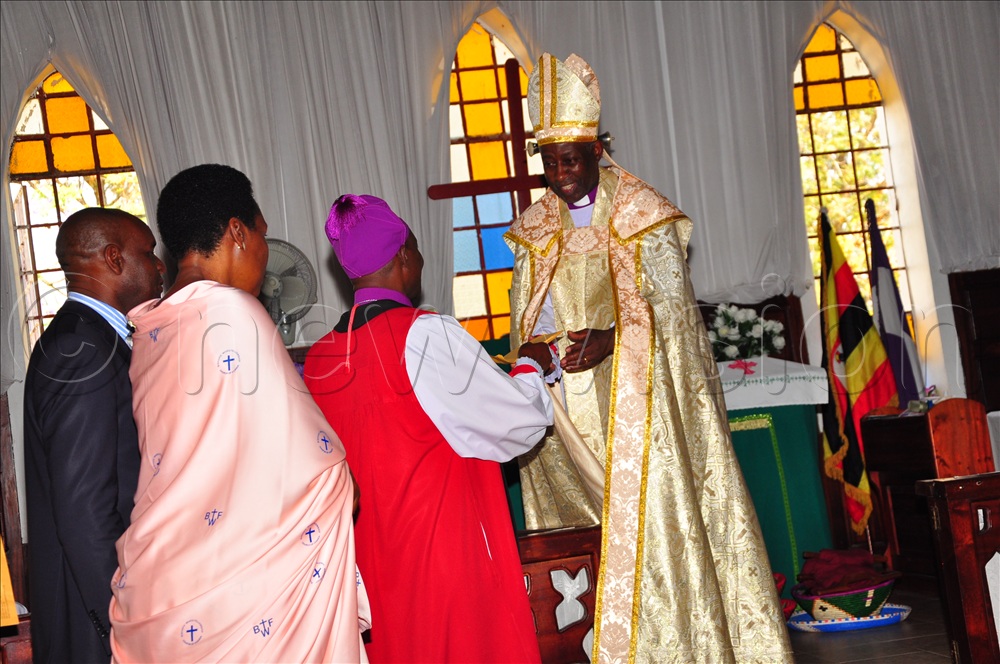 Bishop Ahimbisibwe handing over an envelope as he bids farewell to Archbishop Dr Kaziimba.