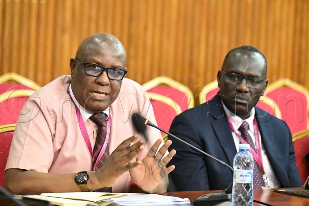 Moses Kamabare, the General Manager/CEO Uganda Medical Stores makes his submissions as Paul Okware, the chief stores and operations looks on before COSASE at Parliament on July 30th, 2026. (All Photos by Maria Wamala)
