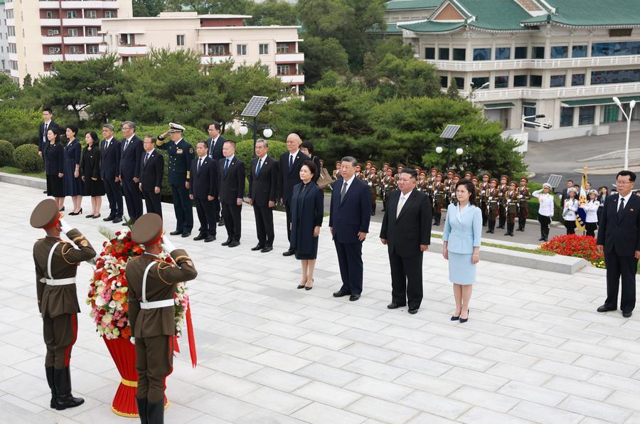 Xi Jinping, general secretary of the Communist Party of China Central Committee and Chinese president, pays homage to the China-DPRK Friendship Tower with his wife Peng Liyuan, in the company of Kim Jong Un, general secretary of the Workers' Party of Korea and president of the State Affairs of the Democratic People's Republic of Korea (DPRK), and Kim's wife Ri Sol Ju, in Pyongyang, June 9. (Xinhua)