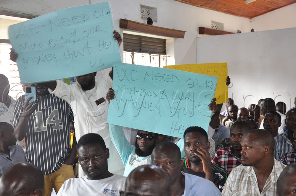 Bushenyi taxi drivers showing placards as they cried for justice during the meeting with Municipal officials.(Credit: Bruno Mugizi