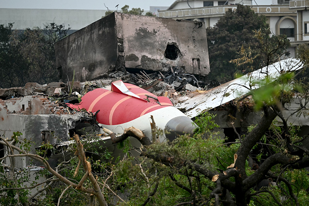 Debris of Air India flight 171 is pictured after it crashed in a residential area near the airport in Ahmedabad on June 13, 2025. India's aviation accident probe agency is facing renewed criticism from pilot groups ahead of the anniversary of the 2025 Air India Boeing-787 crash in Ahmedabad, which killed 260 people. (Photo by Punit PARANJPE / AFP)