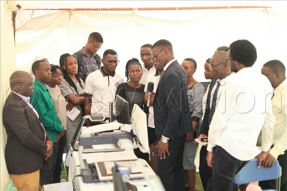 Student explains how the assistive devices work and looking on is Kyebagadha Binasali who is the program technical officer All we see is possibility.