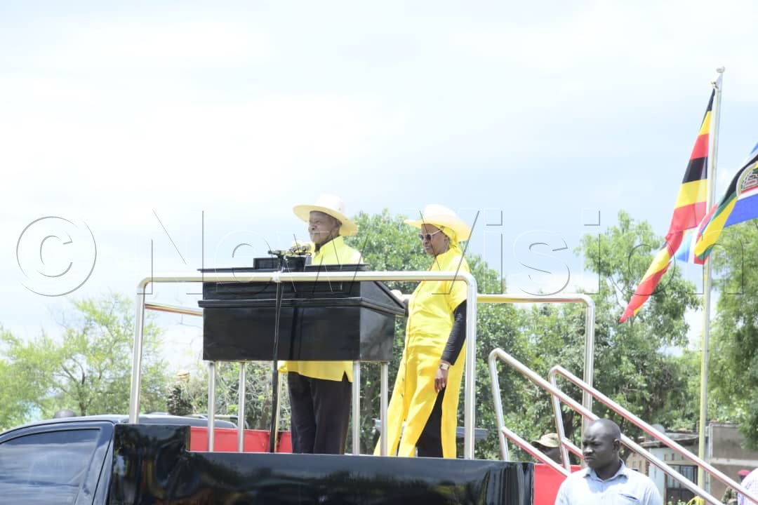 President Museveni and the First Lady on the podium addressing the crowd at the campaign rally.