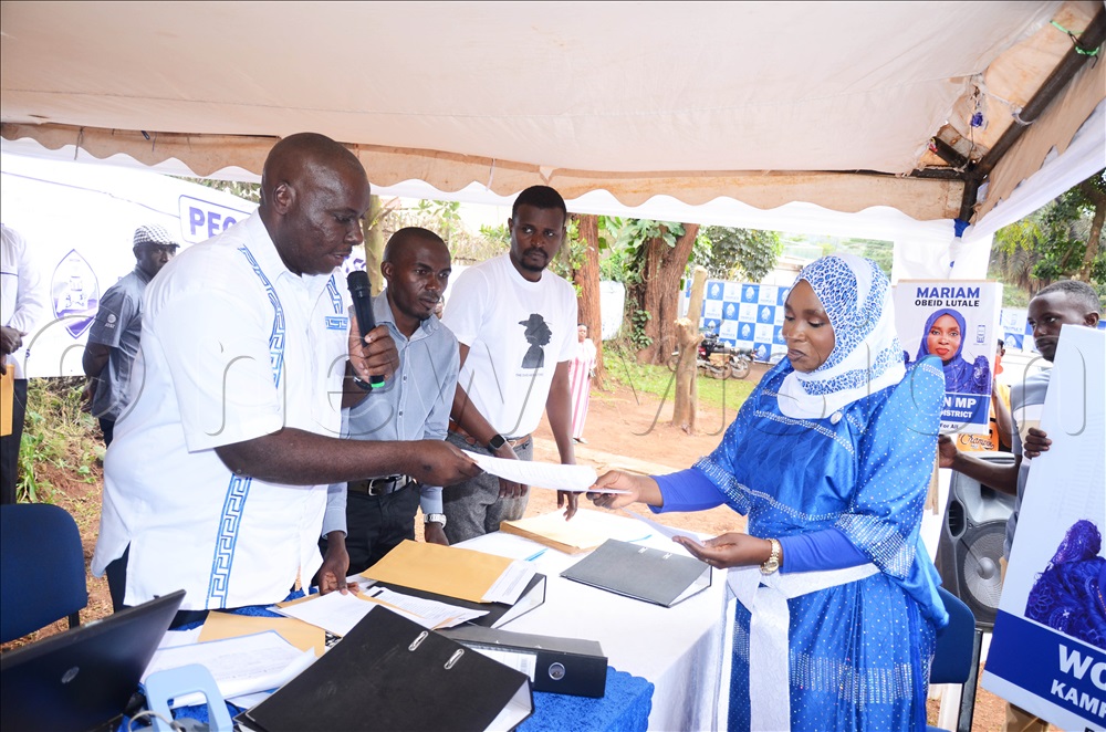 The PFF electoral commission chairperson, Micheal Kabaziguruka handing nomination forms to Miriam Obeid Lutale at Katonga road PFF headquarters in Kampala on Monday.