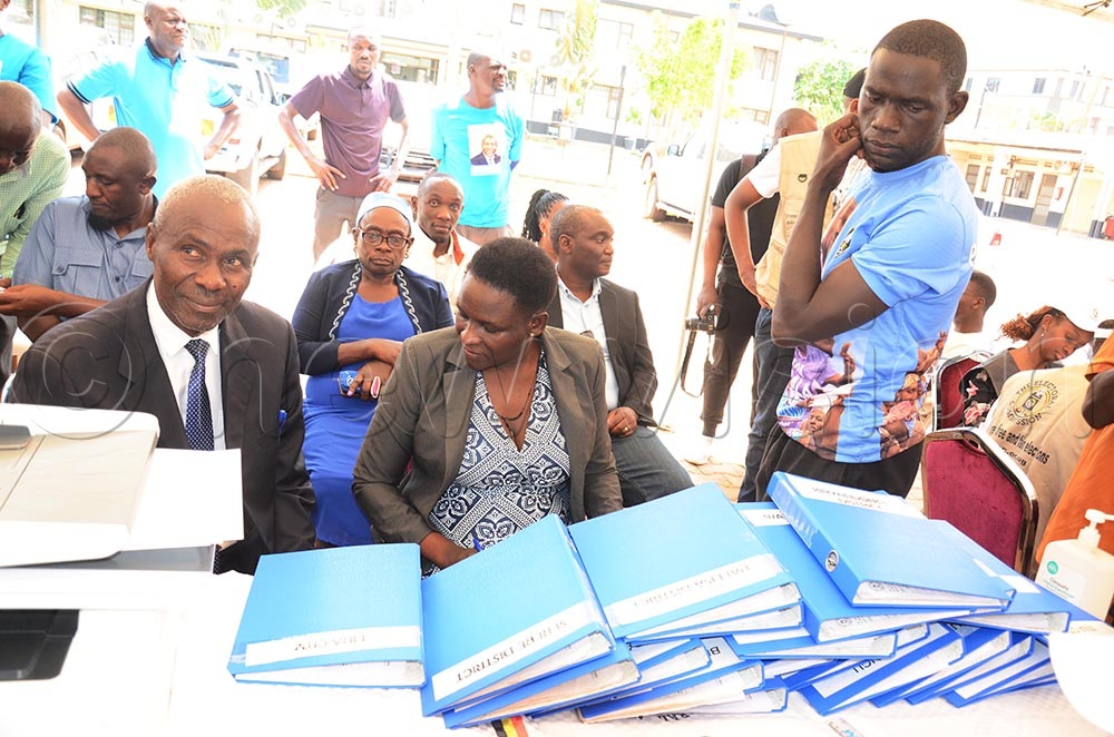 FDC electoral commission chairperson Toterebuka Bamwenda and FDC deputy secretary general, Gloria Paga delivering files of Nandala signatures at EC headquarters on Friday. (Credit: Isaac Nuwagaba) 