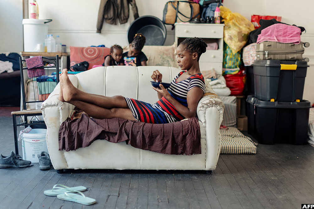 A woman eats her lunch on a couch in one of the halls of an occupied building in downtown Cape Town. 