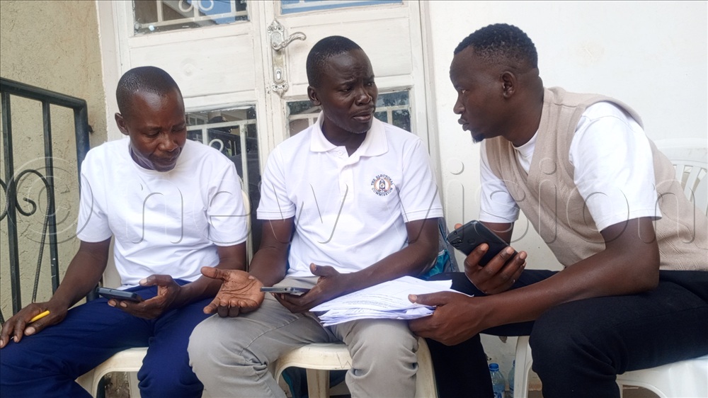 LC V hopeful Leonard Okware in brown sweater with Electoral Commission staff trying to verify his supporters.