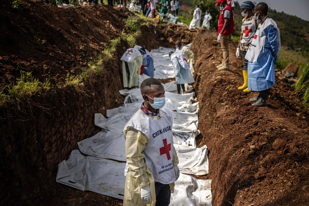  A member of the Congolese Red Cross takes a break as others carry body bags containing human remains during a mass burial for victims of the clashes in eastern Democratic Republic of Congo at Musigiko cemetery in Bukavu on February 20, 2025. (Photo by Luis TATO / AFP)