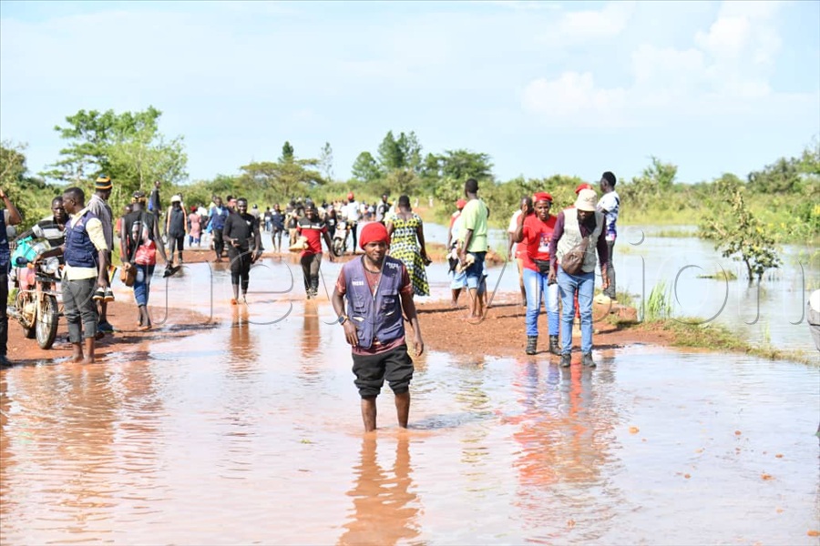 Travelers cross flooded Apac Bridge after River Moroto burst its banks. (Credit: Ponsiano Nsimbi)