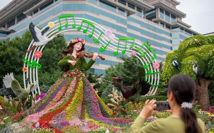 A senior takes pictures of a set of floral decorations at Jianguomen along Chang'an Avenue in Beijing, capital of China, Sept. 25, 2026. Floral decorations have been set up along the Chang'an Avenue in Beijing ahead of China's National Day holidays. (Xinhua)