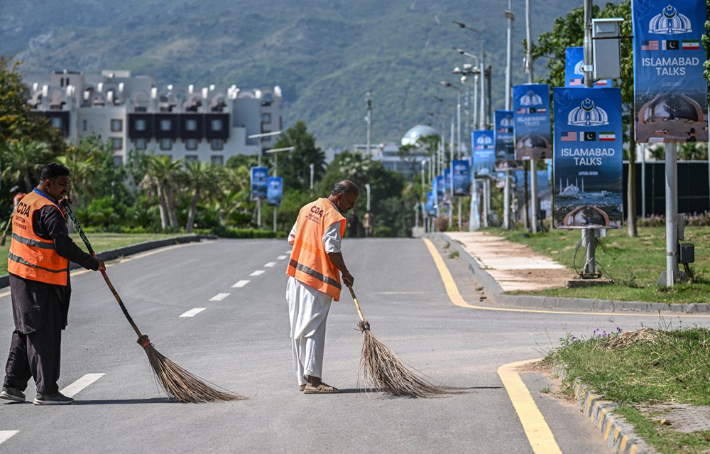 Sanitation workers sweep a road near the Serena Hotel in Islamabad on April 19, 2026. A second round of talks between the United States and Iran is expected in Islamabad this coming week. (Credit: AFP)