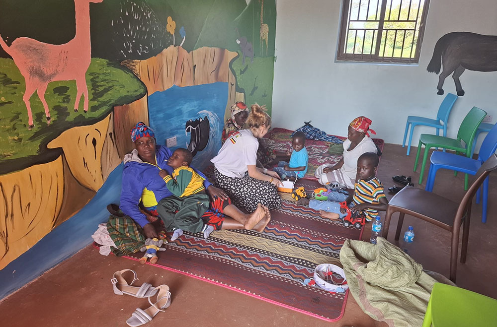 A student interacting with parents and children with special needs at New Dawn International, a non governmental organisation. (Photo by Lydia Nabwire)