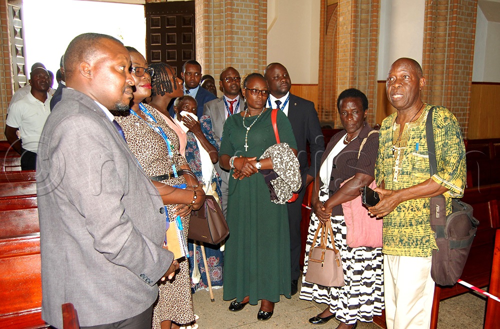 Rev. Fr. Richard Nnyombi of the Missionary Society of the White Fathers (right) taking pilgrims through a tour of the newly-renovated cathedral after the donors' conference on Wednesday, October 21. (Photo by Mathias Mazinga)