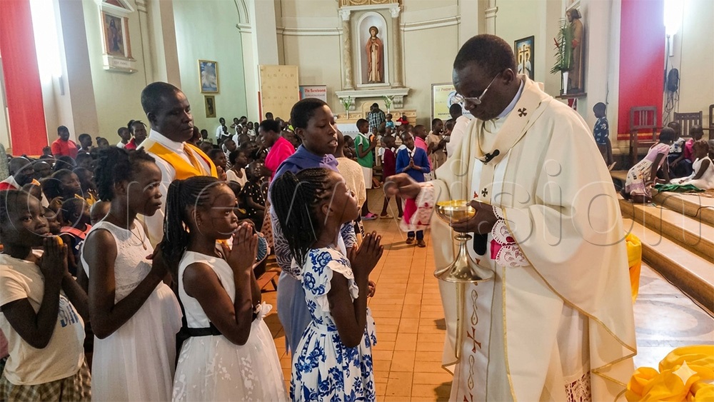 His Grace Raphael P'Mony Wokorach, Archbishop of Gulu Archdiocese giving holy communion to children during the Easter Mass at the St. Joseph's Cathederal in Gulu city. (Photo by Claude Omona)