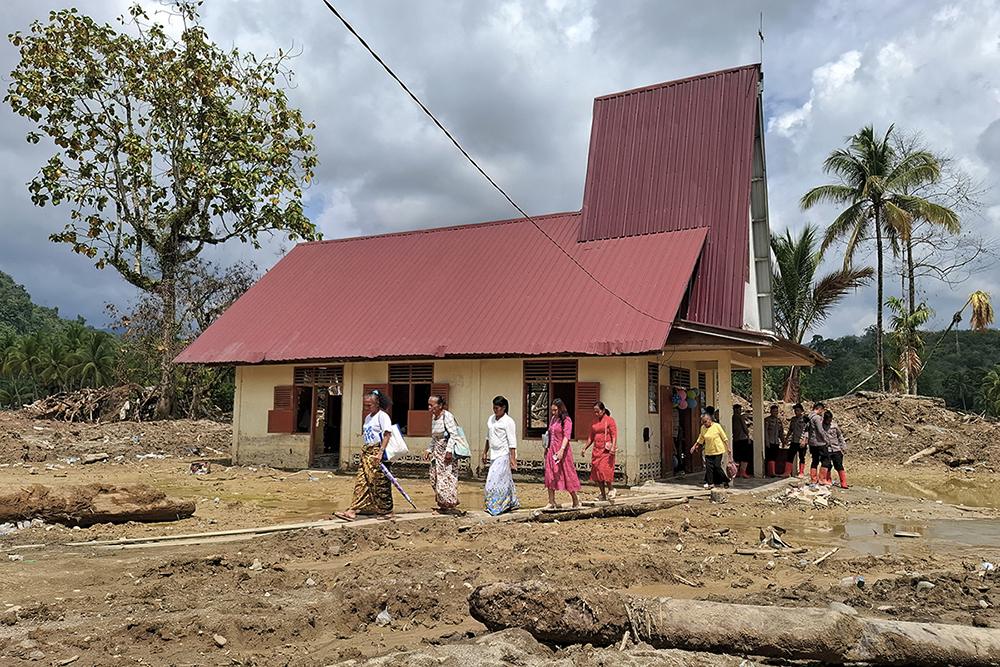 Villagers leave the Angkola Protestant Church at Aek Ngadol village, South Tapanuli, North Sumatra province, on Christmas Day December 25, 2025, in the aftermath of massive flooding and landslides in the area. 