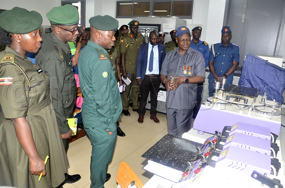Prof. Charles Kwesiga Executive Director of Uganda National Research Institute (right) explains to African Defense forces in the lab how they use mechanized tools to create opportunities to promote the economy. This was during their tour at Namanve Industrial Hub from Senior Command and Staff College Kimaka Jinja where they are undergoing training to prepare after retirement, March 2026. (Photo by Wilfred Sanya)