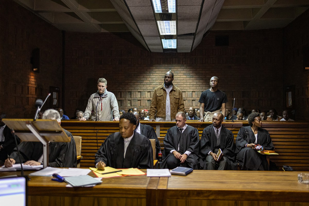 Stellio Gilles Robert Capo Chichi, also known as Kemi Seba (C), his son Khonsou Seba Capo Chichi (R), along with accused co-conspirator Francois Van Der Merwe (L), appear at the Magistrate&rsquo;s Court in Pretoria on April 20, 2026. 
