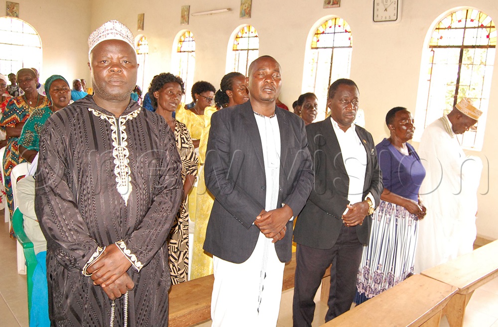 Muslims and Christian pilgrims praying together during mass. (Photo by Mathias Mazinga)
