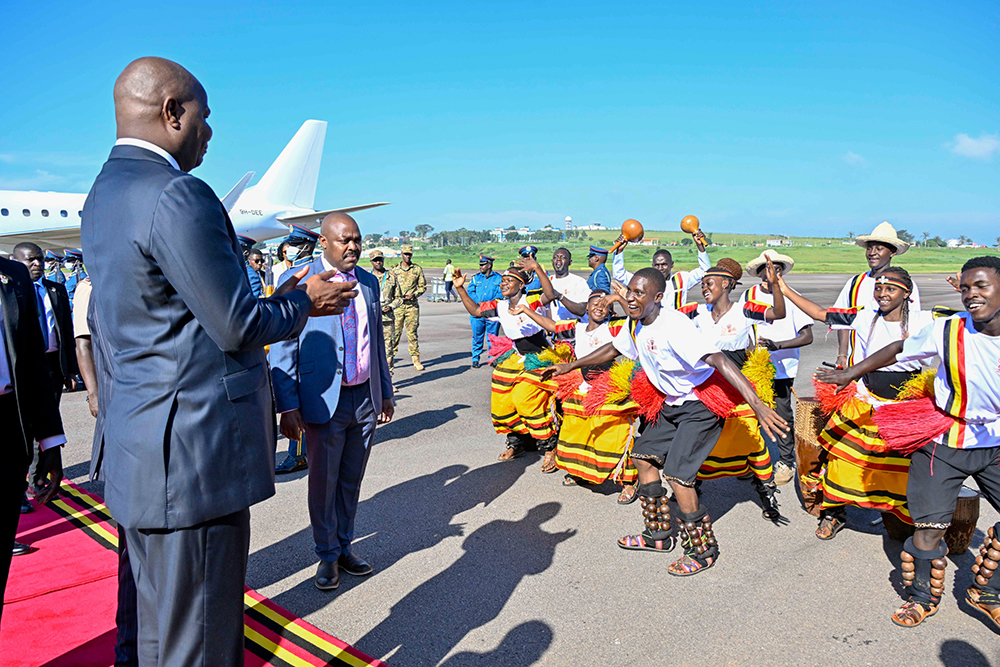 Mozambique President Daniel Francisco Chapo entertained by a group of traditional Ugandan dancers.