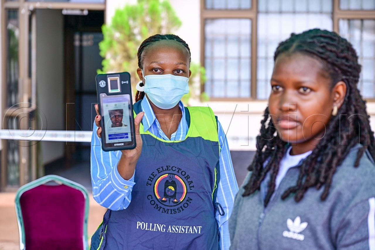 An electoral commission official shows the voters verified face after a facial recognition exercise. (Credit: Miriam Namutebi)