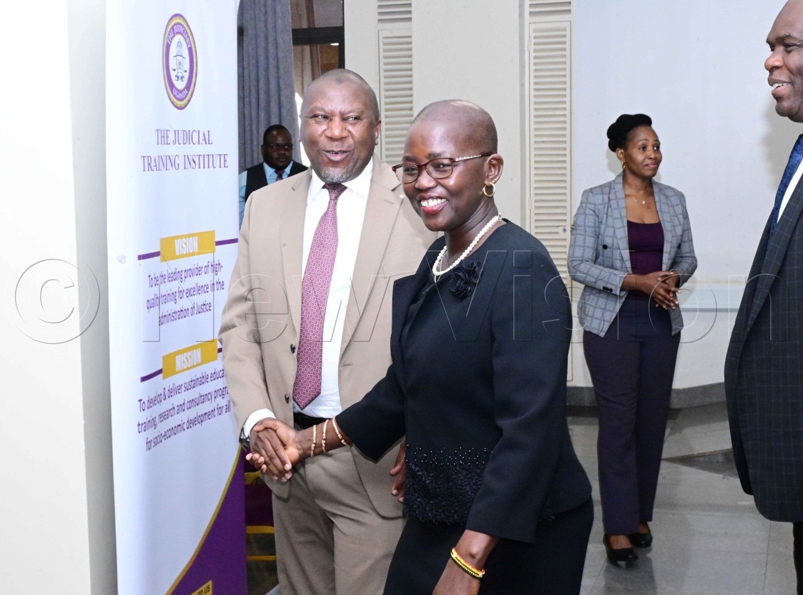 Hon. Justice Musa Ssekaana greeting Lady Justice Jane Frances Abodo.
