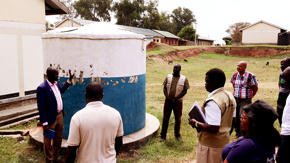 Patrick Ejume, head trainer Omugo Technical school, explains that water from the tank is used by students and for irrigation of vegetables. (Credit: Geofrey Angupale)