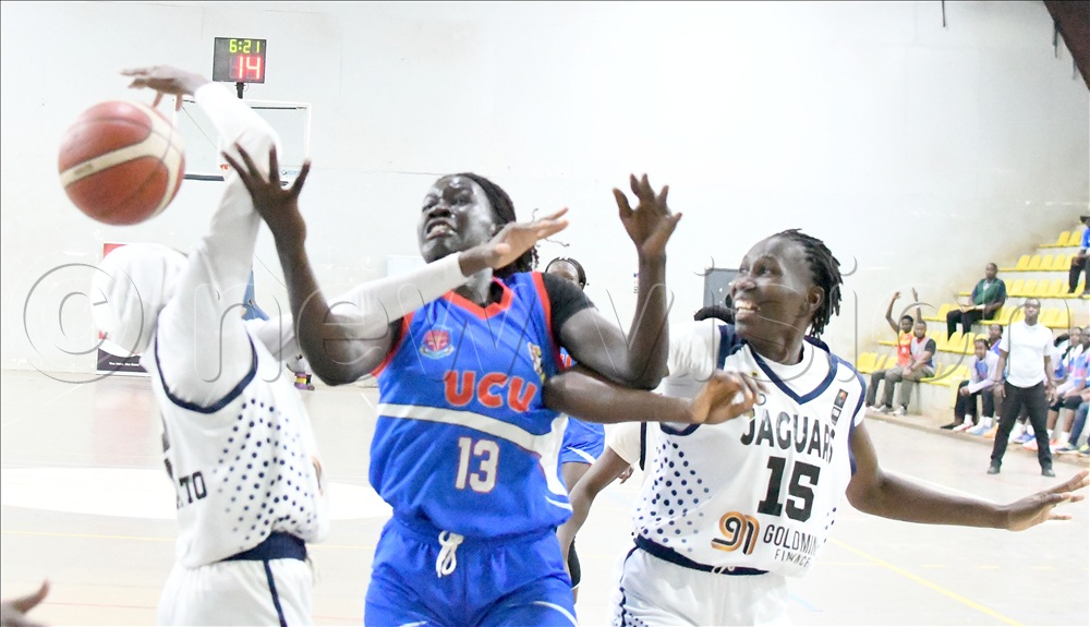 UCU Lady Canons Matrina Anyango (center) fights for a rebound with JT Lady Jaguars' Maimuna Nabbosa (left) Among Annet (right) at the Lugogo Arena, August 31, 2026.