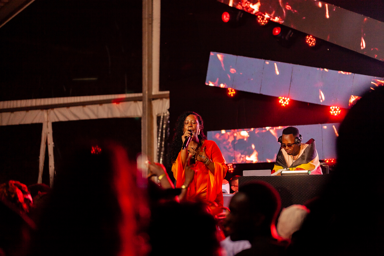 A DJ draped in a Uganda Cranes flag entertains the crowd at Mestil. Photo by Ranell Dickson Nsereko