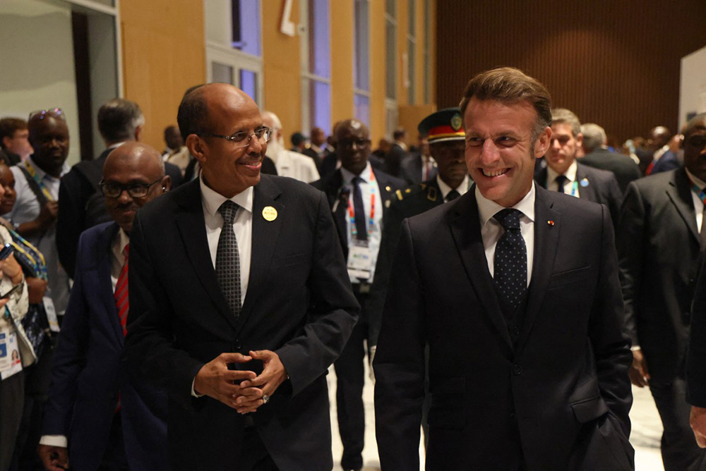  President of France Emmanuel Macron (R) and African Union Commission Chairperson Mahamoud Ali Youssouf (L) smile as they walk together at the Africa Union (AU) - European Union (EU) Summit the Salao Protocolar in Luanda on November 24, 2025. (Photo by Ludovic MARIN / AFP)